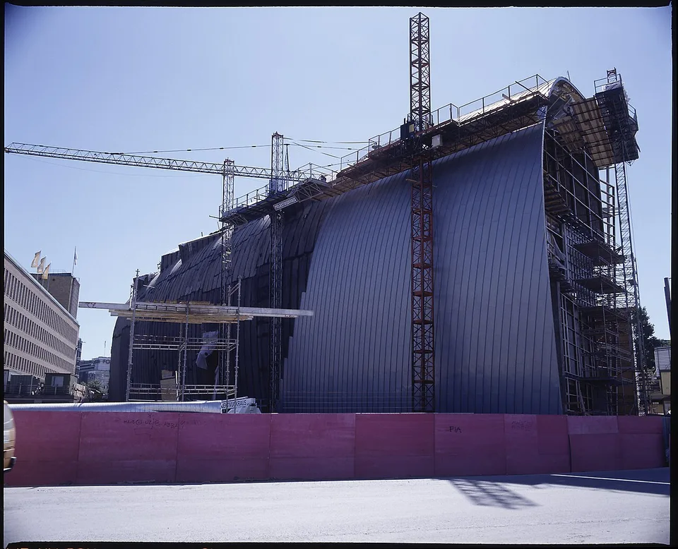 Pose d'un bardage en zinc sur une façade en chantier