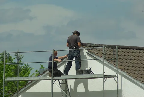 Couvreurs sur l'échafaudage d'un pignon en réfection