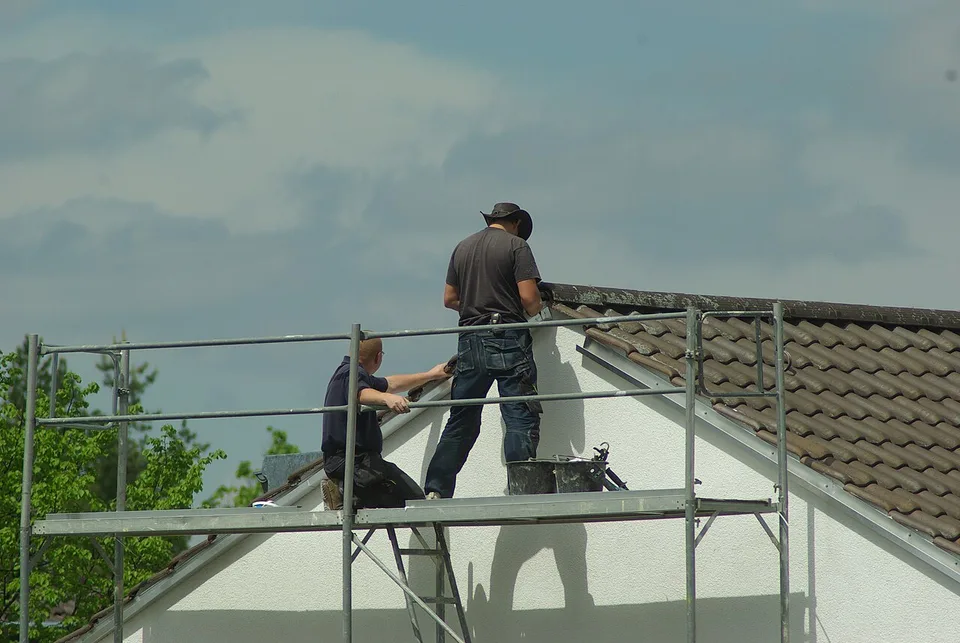 Couvreurs sur l'échafaudage d'un pignon en réfection