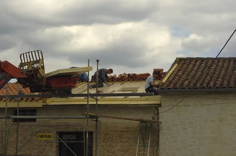 Couvreurs au travail sur un pan de toiture