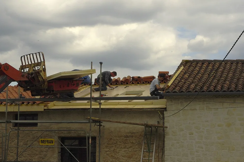 Couvreurs au travail sur un pan de toiture