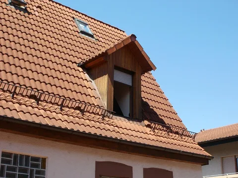 Lucarne et fenêtre de toit dans une couverture en tuiles