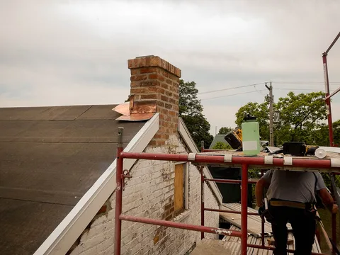Solin en cuivre neuf posé au pied d'une cheminée en briques